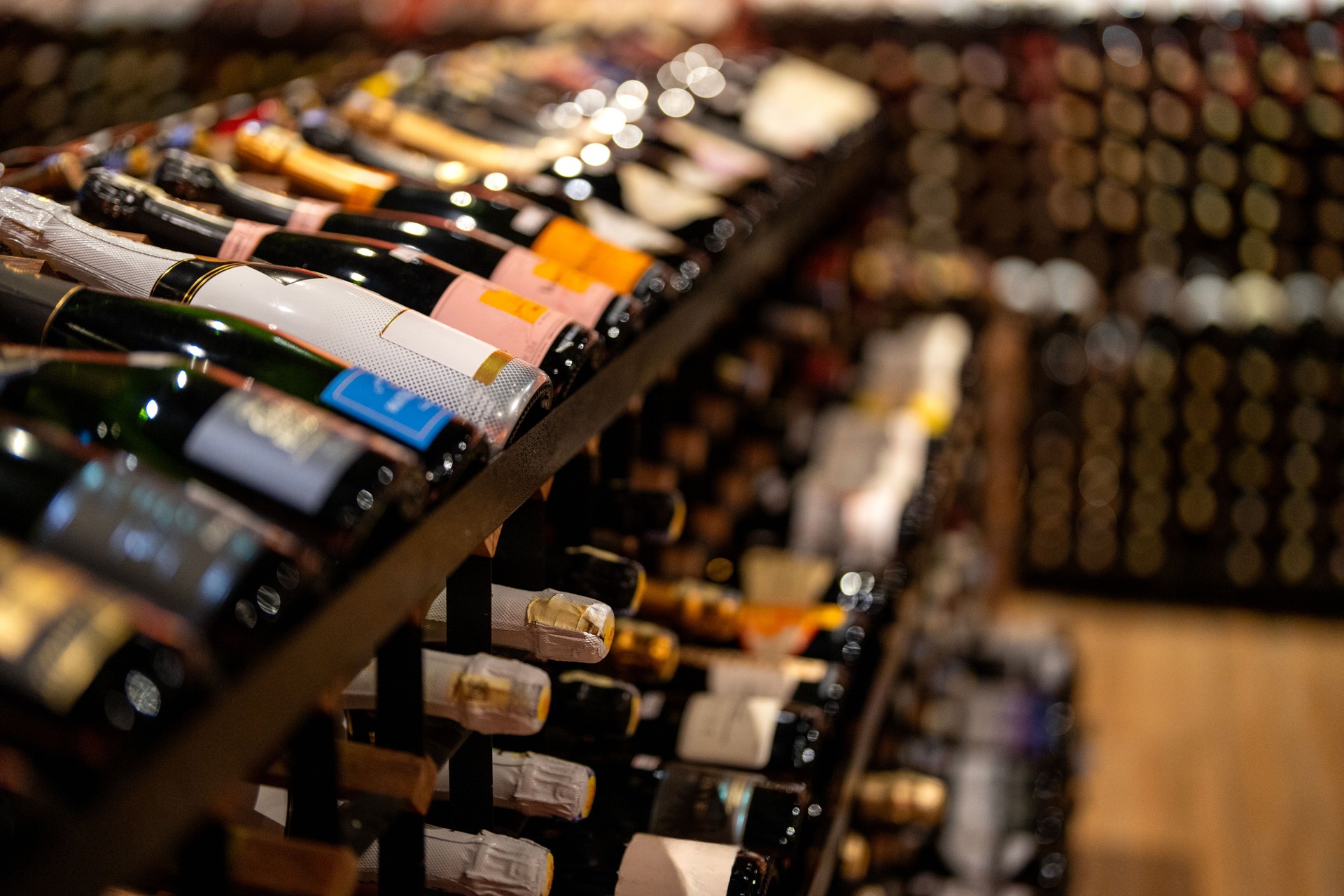 A variety of local and imported wines are displayed on a shelf at a retail shop.